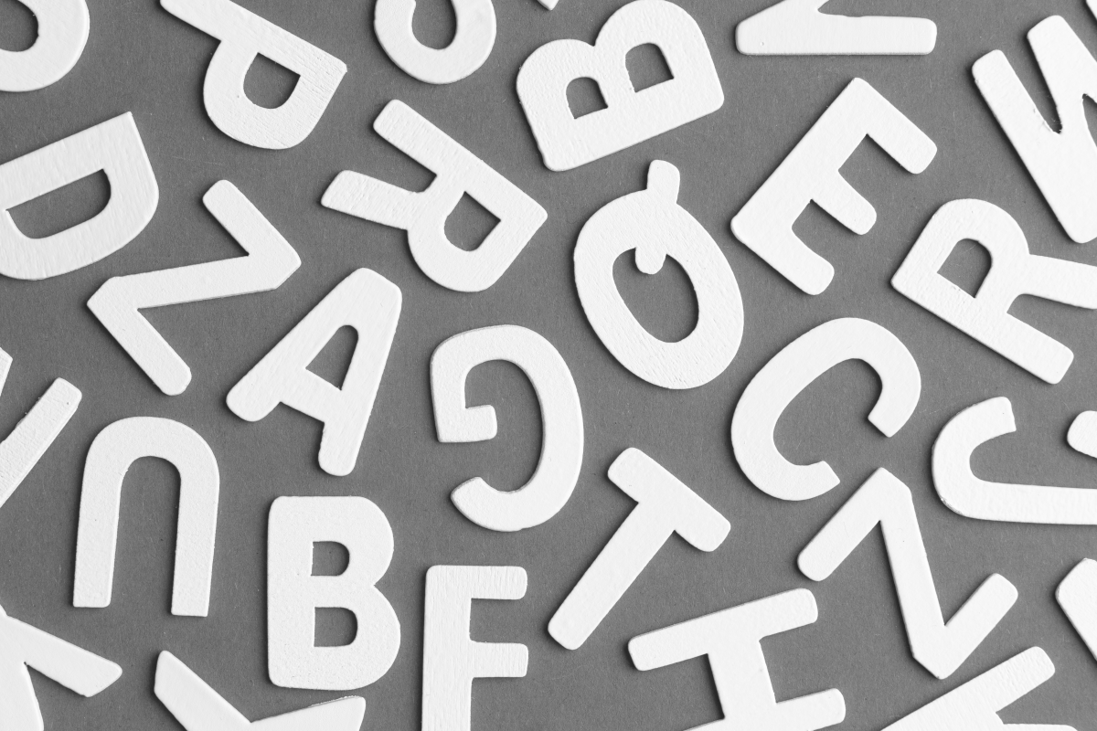 Weiße Großbuchstaben auf grauem Hintergrund